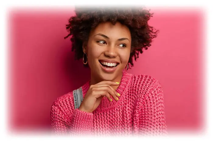 A woman with a pink sweater smiling for the camera.